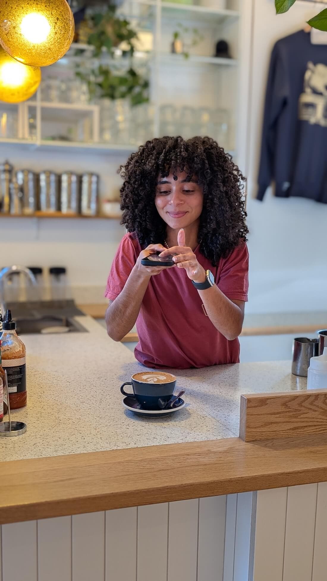 Angèle photographiant un café au comptoir